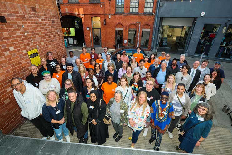 A group of people standing outside of a brick building.
