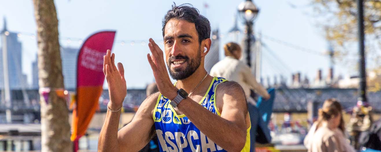 An RSPCA fundraiser wearing a running vest completing a running event.