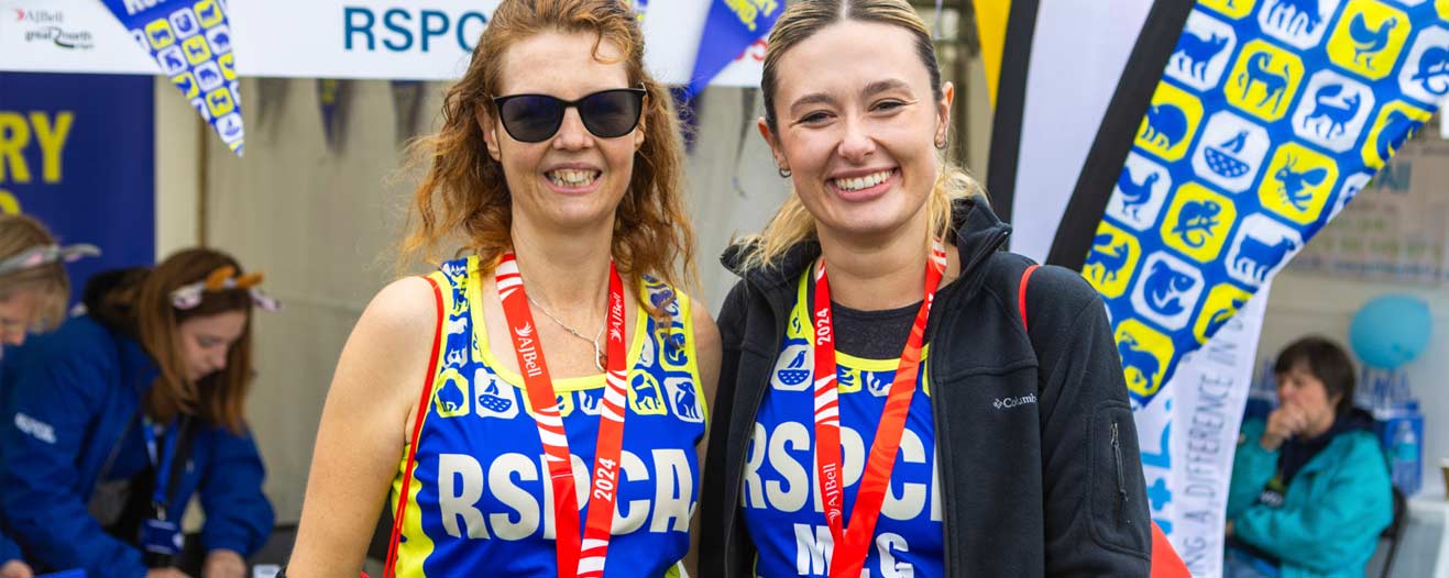Two women with their medals after finishing their charity run.