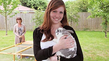Teenage girl stroking ginger cat