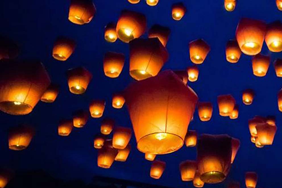 Sky lanterns floating in the night sky.
